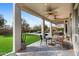 Comfortable, covered patio area with ceiling fans, a dining table, and views of the backyard and pool at 7357 E Rochelle Cir, Mesa, AZ 85207