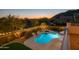 Scenic backyard at sunset featuring a pool, spa, outdoor lighting, and mountain views for a luxurious outdoor experience at 7357 E Rochelle Cir, Mesa, AZ 85207