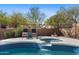 Relaxing spa spills into a luxurious backyard pool, surrounded by seating for the ultimate oasis at 7357 E Rochelle Cir, Mesa, AZ 85207