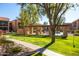 Green lawn has sidewalk leading to the gated community pool, which has apartments in the background at 8260 E Arabian Trl # 170, Scottsdale, AZ 85258