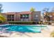 Community pool with a shallow ledge and metal access steps is surrounded by apartments and mature landscaping at 8260 E Arabian Trl # 170, Scottsdale, AZ 85258