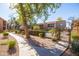 Community pool area features a curved walkway with green grass and shrubbery that leads up to the fenced pool area at 8260 E Arabian Trl # 170, Scottsdale, AZ 85258