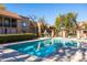 A community pool with lounge seating is surrounded by apartments and mature trees, offering a relaxed atmosphere at 8260 E Arabian Trl # 170, Scottsdale, AZ 85258