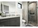 Modern bathroom with gray vanity, granite countertop, and a glass-enclosed shower with convenient toiletry nooks at 8822 E Chino Dr, Scottsdale, AZ 85255