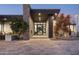 Contemporary front entrance with custom glass door, stone accents, and desert-friendly landscaping at 8822 E Chino Dr, Scottsdale, AZ 85255