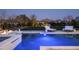 Nighttime shot of a luxurious pool with perimeter lighting, fire features, and mountain views at 8822 E Chino Dr, Scottsdale, AZ 85255