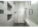 Modern shower with herringbone pattern insets, dual shower heads, and glass door with matching bench seat at 8822 E Chino Dr, Scottsdale, AZ 85255