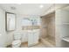 Bathroom featuring a window, tiled shower, toilet, and a white cabinet vanity at 9156 W Garfield St, Tolleson, AZ 85353