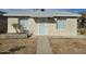 Classic single-story home featuring a walkway leading to an elegant white front door and symmetrical window placements at 9156 W Garfield St, Tolleson, AZ 85353