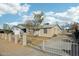 Charming single-story home featuring a secure metal gate, mature trees, and desert landscaping for easy maintenance at 9156 W Garfield St, Tolleson, AZ 85353