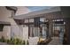 Close-up of a modern home's exterior showcasing travertine accents, large windows, desert landscaping, and outdoor living spaces at 9290 E Thompson Peak Pkwy # 401, Scottsdale, AZ 85255