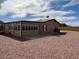 Exterior view of home with gravel landscaping, patio and sunroom at 970 W Diamond Rim Dr, Casa Grande, AZ 85122