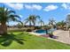 The spacious backyard features a pool, a manicured lawn, desert plants and a wrought-iron fence at 9765 E Lompoc Ave, Mesa, AZ 85209