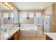 Bathroom features a vanity with dual sinks, tile flooring, a glass shower and a separate soaking tub at 9765 E Lompoc Ave, Mesa, AZ 85209