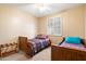 Cozy bedroom featuring two beds, a ceiling fan, plantation shutters and warm neutral paint at 9765 E Lompoc Ave, Mesa, AZ 85209