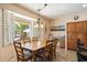 Bright dining area with wood table set, large window views, and plantation shutters at 9765 E Lompoc Ave, Mesa, AZ 85209