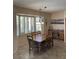 Well-lit dining room featuring a wooden table set, plantation shutters, and tiled floors at 9765 E Lompoc Ave, Mesa, AZ 85209