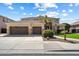 Charming beige two-story home featuring a three-car garage, desert landscaping, and a welcoming entryway at 9765 E Lompoc Ave, Mesa, AZ 85209