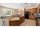 Well-appointed kitchen featuring wooden cabinets, granite countertops, black appliances, and a breakfast bar at 9765 E Lompoc Ave, Mesa, AZ 85209