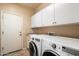 Functional laundry room with modern appliances, ample storage, and a clean, organized layout at 9765 E Lompoc Ave, Mesa, AZ 85209