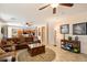 Spacious living room showcases a large brown sectional sofa, a ceiling fan and decorative tile flooring at 9765 E Lompoc Ave, Mesa, AZ 85209