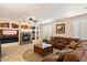 Cozy living room features a fireplace with decorative built-ins, ceiling fan, and a comfortable sectional sofa at 9765 E Lompoc Ave, Mesa, AZ 85209