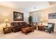 Cozy living room with dark brown leather sofa, neutral walls, and plantation shutters at 9765 E Lompoc Ave, Mesa, AZ 85209