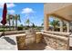 Outdoor kitchen equipped with a stainless steel grill, set in a stone surround with a beautiful patio view at 9765 E Lompoc Ave, Mesa, AZ 85209