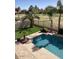 Beautiful backyard with a refreshing pool, manicured landscaping, and serene golf course views at 9765 E Lompoc Ave, Mesa, AZ 85209