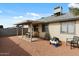 Exterior view of the backyard showcasing a covered patio and desert landscaping at 9853 E Birchwood Ave, Mesa, AZ 85208