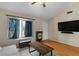 Comfortable living space with wood-look floors, a large window, and a television mounted on the wall at 9853 E Birchwood Ave, Mesa, AZ 85208