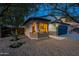 Cozy single-story home featuring bay windows, a blue garage door, and desert landscaping at 10594 E Wallflower Ln, Florence, AZ 85132