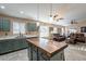 Open-concept kitchen with wooden island, modern appliances, stylish cabinets, and seamless transition to the living room at 10594 E Wallflower Ln, Florence, AZ 85132