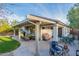 Large covered patio ideal for outdoor entertaining, featuring ceiling fans, ample seating, and grill at 10594 E Wallflower Ln, Florence, AZ 85132