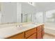 Well-lit bathroom with double sinks, framed mirror, and tiled floors at 1148 S Sierra St, Gilbert, AZ 85296