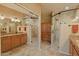 Bright bathroom featuring a large mirror, dual vanities, granite countertops, and a tiled walk-in shower at 11500 E Cochise Dr # 2088, Scottsdale, AZ 85259