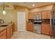 Traditional kitchen with stainless steel appliances, tile backsplash, stone countertops, and tan-colored cabinets at 11500 E Cochise Dr # 2088, Scottsdale, AZ 85259