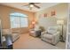 Cozy living room featuring plush chairs, a large window, and a modern ceiling fan at 11500 E Cochise Dr # 2088, Scottsdale, AZ 85259