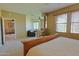 Bright main bedroom with tan carpet and paint, wooden window blinds, access to sitting room and view of exterior at 11500 E Cochise Dr # 2088, Scottsdale, AZ 85259