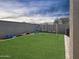 Artificial grass backyard featuring a play area with swings, slide, and a block wall for privacy at 12017 N 151St Dr, Surprise, AZ 85379