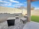 Backyard patio area with a fire pit, outdoor chairs, and artificial grass, perfect for entertaining guests outdoors at 12017 N 151St Dr, Surprise, AZ 85379