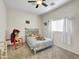 bedroom with a ceiling fan, window with white curtains, and a full size bed covered with stuffed animals at 12017 N 151St Dr, Surprise, AZ 85379