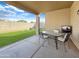 Covered patio with outdoor seating, a television, and artificial grass backyard with a view of the playground at 12017 N 151St Dr, Surprise, AZ 85379