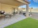 Covered patio with outdoor seating, a barbecue, and a lush artificial grass backyard for low-maintenance living at 12017 N 151St Dr, Surprise, AZ 85379