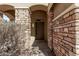 Inviting entrance to a home with stone pillars and a wooden door at 12132 W Ashby Dr, Peoria, AZ 85383