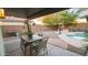 Inviting backyard with a covered patio, dining area, pool, and desert landscaping, perfect for outdoor entertaining at 13451 S 47Th Way, Phoenix, AZ 85044