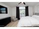 Bedroom with a sleek dresser, television, and a cozy armchair next to a bright window at 13451 S 47Th Way, Phoenix, AZ 85044