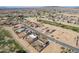 Aerial view showcases a desert community with a golf course, nearby ponds, and homes with solar panels at 14493 S Country Club Dr, Arizona City, AZ 85123