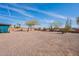 Large, gravel backyard featuring mature trees and a block wall fence offering both space and privacy at 14493 S Country Club Dr, Arizona City, AZ 85123