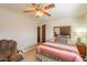 Comfortable bedroom features a ceiling fan, mirror, and cozy chair for a relaxing space at 14493 S Country Club Dr, Arizona City, AZ 85123